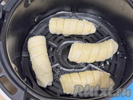 В чашке взбить вилкой яичный желток. Смазать поверхность слоек, находящихся в чаше аэрогриля, взбитым желтком. Отправить чашу в аэрогриль. Установить температуру 150 градусов, время - 15 минут. Выпекать до красивого золотистого цвета&nbsp;слоёного теста.