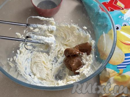 Масло взбить миксером 2 минуты, затем частями добавить варёную сгущёнку, каждый раз перемешивая крем миксером до однородности.