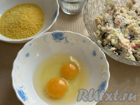 В одну тарелку насыпать панировочные сухари (можно использовать в качестве панировки и панировочную смесь "Темпура"). Во вторую тарелку вбить сырые яйца.
