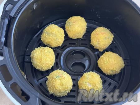 Суши-шарик, покрытый яичным кляром и панировкой, выложить на решётку аэрогриля. Аналогично обвалять в кляре и панировке столько шариков, сколько у вас одновременно поместятся в чашу аэрогриля. Выкладывать суши-шарики на решётку аэрогриля нужно в один слой. У меня в чашу аэрогриля помещаются 7 суши-шариков, именно столько я и покрыла панировкой. Остальные шарики я запекала в следующие заходы. Чашу с суши-шариками в панировке отправить в аэрогриль.