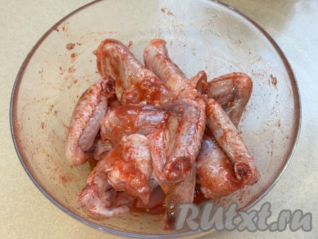 Тщательно перемешать крылья, покрывая их мёдом, маслом, чесноком и специями со всех сторон. Оставить крылышки мариноваться при комнатной температуре минут на 30. Для того чтобы крылья равномерно пропитались медово-чесночным соусом, в процессе маринования их нужно будет 2-3 раза перемешать.