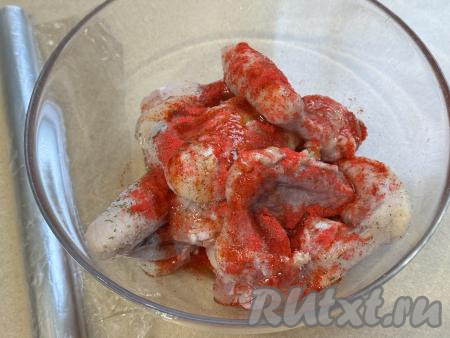 Подготовленные крылья выложить в достаточно глубокую миску, влить растительное масло и жидкий мёд, всыпать соль и специи (в качестве специй я добавила соль с зеленью и 1 чайную ложку паприки). Сюда же выложить пропущенный через пресс чеснок.&nbsp;