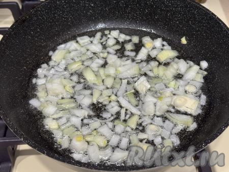 В сковороду влить растительное масло, разогреть, выложить мелко нарезанную луковицу. Обжарить лук на среднем огне до прозрачности (примерно в течение 3-4 минут), не забывая время от времени перемешивать.