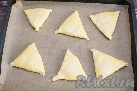 В чашке яичный желток взболтать кулинарной кисточкой до однородности. Смазать каждую заготовку самсы взбитым желтком.