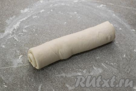 Размороженное слоёное тесто, не раскатывая, на припылённом мукой столе свернуть в плотный рулет.