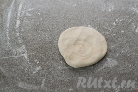 Рулетик из слоёного теста прижать сверху рукой, чтобы получилась круглая лепёшка.