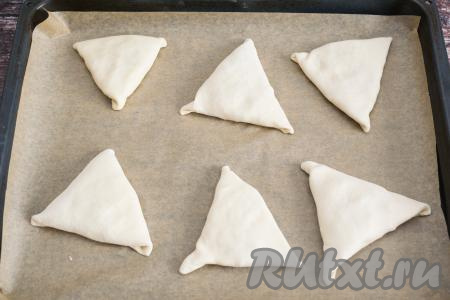 Противень застелить пергаментом. Сформированную заготовку самсы выложить на противень швом вниз. Аналогично сформировать и выложить на противень ещё 5 заготовок самсы.