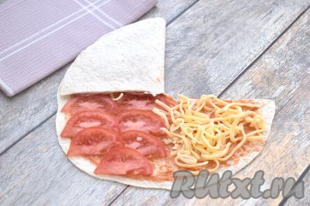 Берёмся за часть лепёшки, на которой расположена колбаса, и аккуратно накрываем ею часть с сыром.