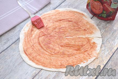 В результате у нас получится круглая заготовка из тортильи с разрезом, как на фото. С помощью кулинарной кисточки смазываем лепёшку 1 столовой ложкой кетчупа (или томатного соуса), немного отступая от краёв лепёшки.