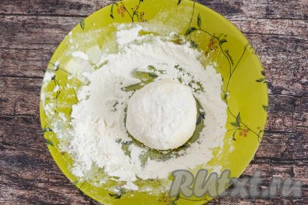 Приплюснуть рукой сырник, чтобы он приобрёл привычную форму. На тарелку насыпать муку. Обвалять сформированный сырник с вареньем со всех сторон в муке.