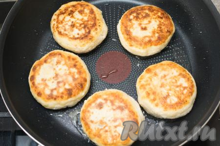 Жарить сырники на среднем огне по 3-4 минуты с каждой стороны (до характерного румянца с двух сторон). Затем сделать огонь минимальным, ещё раз перевернуть сырники, накрыть сковороду крышкой и потомить 2-3 минуты. Выключить огонь и дать сырникам ещё пропариться 5 минут, не открывая крышку сковороды.&nbsp;