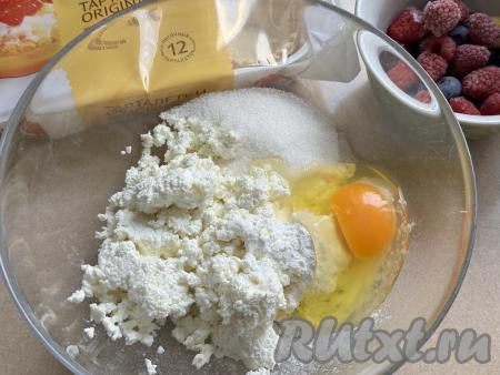 В глубокой миске соединить творог, сахар и крахмал, вбить сырое яйцо.&nbsp;