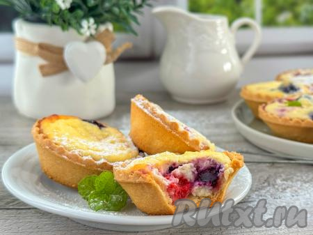 Противень с готовой выпечкой достать из духовки. Аппетитные тарталетки с нежной начинкой из творога и ягод тёплыми или полностью остывшими&nbsp;подать к столу. Перед подачей я слегка присыпала их сахарной пудрой. А вот как эта вкусная выпечка выглядит в разломе. Угощайтесь!