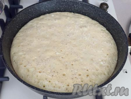 Поставить сковороду на медленный огонь, накрыть крышкой, выпекать шарлотку с яблоками минут 15-20. За это время поверхность пирога станет сухой, снизу он подрумянится.