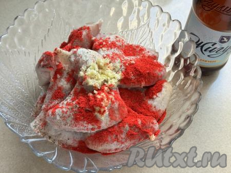 Подготовленные куриные крылья выложить в глубокую миску, добавить соль, пропущенный через пресс чеснок и специи (в качестве специй я всыпала 1 чайную ложку паприки).