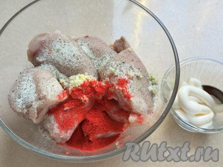 В миску выложить филе бёдер, посолить, добавить специи и чеснок, пропущенный через пресс. В качестве специй я добавила 1 чайную ложку молотой паприки и пряную соль.