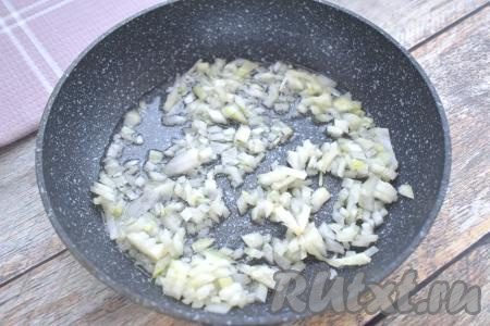 Для формирования этих пирожков с капустой можно взять как слоёное дрожжевое тесто (его я и использовала), так и слоёное бездрожжевое тесто. Достаём слоёное тесто из морозилки и оставляем его размораживаем при комнатной температуре. Пока тесто размораживается, приготовим начинку из капусты для пирожков. Для этого очищаем морковку и лук. Хорошо прогреваем растительное масло в достаточно глубокой сковороде, после этого выкладываем мелко нарезанный лук. Обжариваем лук до мягкости (минуты 3), иногда помешивая, на среднем огне.