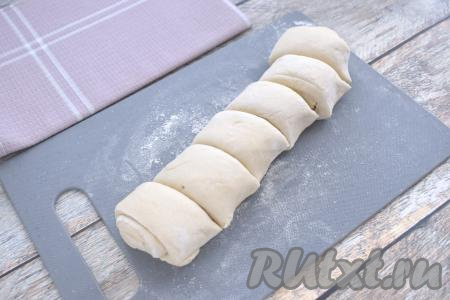Размороженное слоёное тесто на поверхности, немного присыпанной мукой, не раскатывая, сворачиваем в плотный рулет. Получившийся рулет из слоёного теста нарезаем на 6 одинаковых кусочков.