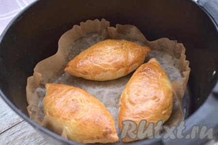 Включаем аэрогриль на 160 градусов, а время выставляем на 25 минут. Через 15 минут пирожки с капустой нужно перевернуть и продолжить их готовить в аэрогриле оставшиеся 10 минут. Готовые пирожки должны стать приятного золотистого цвета с двух сторон. Готовую выпечку переложить из чаши аэрогриля на тарелку. После первой партии пирожков аналогично приготовить оставшиеся 3 пирожка, не забыв перед выпечкой смазать их взбитым яйцом. Я выпекала в аэрогриле мощностью 1400 ватт с одним ТЭНом, за 25 минут пирожки были полностью готовы. Если у вас аэрогриль другой мощности, ориентируйтесь на его свойства.