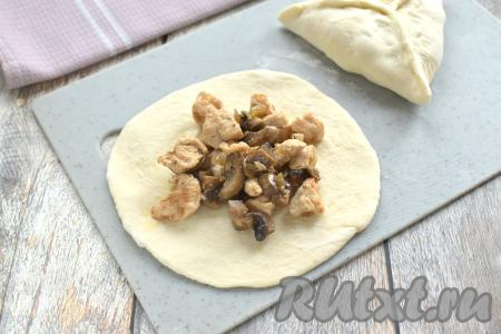 Остывшую курино-грибную начинку зрительно делим на 5 частей. В центр раскатанной круга из слоёного теста выкладываем одну часть начинки.