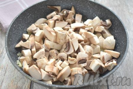 К обжаренному луку добавляем шампиньоны, нарезанные на средние кусочки. Обжариваем лук с грибами минут 8 (до испарения жидкости из шампиньонов), иногда перемешивая. В процессе жарки солим по вкусу грибы с луком. Как только жидкость из шампиньонов выпарится, убираем сковороду с огня. Жареные грибы с луком перекладываем со сковороды в миску.