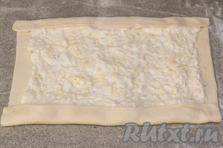 Подвернуть на начинку два длинных края пласта слоёного теста.