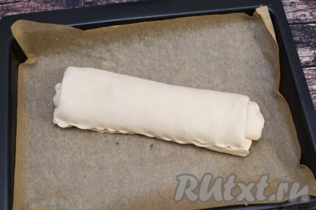 Противень для выпечки застелить пергаментом, выложить рулет. Старайтесь, чтобы шов рулета был или снизу, или сбоку. Я дополнительно прищипнула руками тесто в районе шва, чтобы начинка не вытекала во время выпечки.