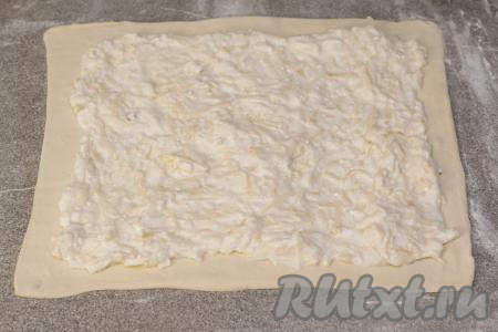 На раскатанный пласт теста выложить творожно-яблочную начинку, отступив от краёв теста примерно по 1,5 сантиметра.