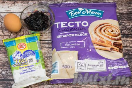 Подготовить продукты для приготовления слоек с творогом и вареньем. Варенье можно взять любое (у меня - варенье из чёрной смородины). Лучше, если варенье будет не очень жидким. Для этих слоек можно взять как бездрожжевое слоёное тесто (его я и купила), так и дрожжевое слоёное тесто. Достать слоёное тесто из морозилки и дать ему разморозиться при комнатной температуре. Творог подойдёт любой жирности (в этот раз я купила жирностью 5%).