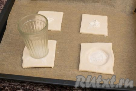 В центре каждого квадрата из слоёного теста дном стакана сделать углубление для начинки слоек. Мука, которая насыпана на тесто, не даст дну стакана пристать к тесту и углубление сформируется и просто, и быстро.