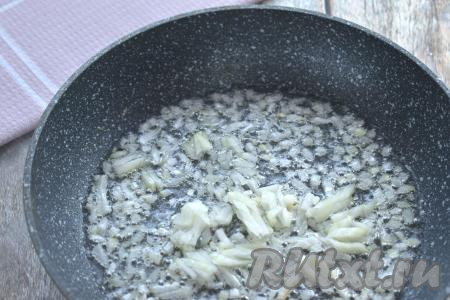 Пока варится рис, можно заняться фаршем. Для начинки курника можно взять фарш из любого мяса (у меня - из свинины). Фарш можно приготовить в домашних условиях, пропустив кусочки мяса через мясорубку, но можно использовать и покупной фарш. Разогреваем на сковороде растительное масло, выкладываем мелко нарезанный очищенный лук. Иногда помешивая, обжариваем лук до мягкости (минуты 3-4) на среднем огне.