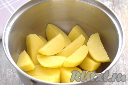 Очищаем картошку. Если картофель крупный, разрезаем его на несколько частей, выкладываем в кастрюлю, заливаем полностью водой, ставим на сильный огонь. После закипания воды добавляем соль, уменьшаем огонь, варим до готовности картошки (минут 25, полностью готовые картошины будут легко прокалываться ножом).&nbsp;