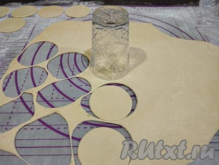 Каждую часть теста на присыпанной мукой поверхности раскатываем скалкой в тонкий пласт (толщиной ориентировочно 2 миллиметра), вырезаем стаканом кружочки (я использовала стакан&nbsp;диаметром 7 сантиметров).