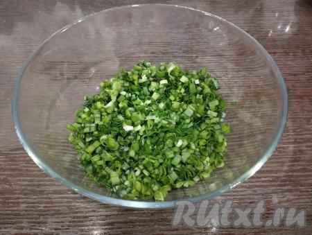 Пока тесто для наших вареников отдыхает, приготовим начинку. Для этого зелёный лук мелко режем и выкладываем в глубокую миску.