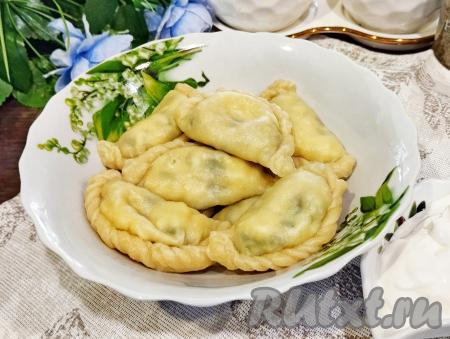 Готовые вареники с нежной начинкой из зелёного лука и яиц выкладываем на тарелку и в горячем виде подаём к столу&nbsp;со сметаной или другим вашим любимым соусом.&nbsp;