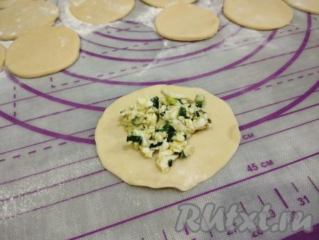 На каждый кружочек теста выкладываем 1 чайную ложку начинки из яиц и зелёного лука.