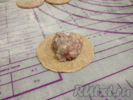 На каждый кружочек теста из цельнозерновой муки выкладываем неполную чайную ложку мясной начинки.