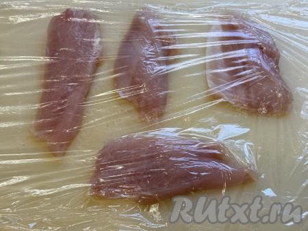 Куриное филе нарезать на плоские кусочки толщиной 1,5 сантиметра. У меня получились 7 кусочков из двух филе. Выложить кусочки филе на разделочную доску, накрыть пищевой плёнкой.
