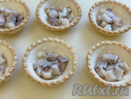 Филе сельди внимательно осмотреть, если есть косточки, их нужно будет удалить. Нарезать селёдку на мелкие кубики и выложить на дно тарталеток. Я формировала закуску в 6 песочных тарталетках.