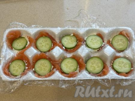 Свежий огурец нарезать на кружочки. Положить по одному кружочку огурца на творожный сыр и слегка прижать.