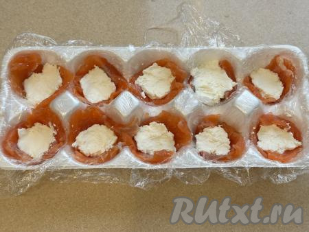 В каждую лунку с красной рыбой выложить по 1 чайной ложке творожного сыра.