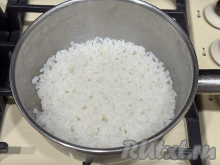 В сотейник с рисом влить 170 миллилитров воды комнатной температуры, поставить на достаточно сильный огонь. Как только вода закипит, подсолить, перемешать, убавить огонь до минимума и варить рис под крышкой до полного впитывания воды и готовности риса (рисинки должны стать мягкими, но не переваренными). Обычно на варку требуется минут 15-20. Рис во время варки не перемешивать. Готовый рис убрать с огня, перемешать, полностью остудить.