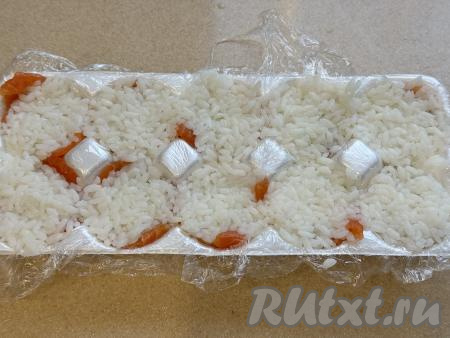 Затем выложить в ячейки остывший варёный рис, заполняя полностью ячейки, немного утрамбовать.