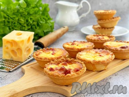 Аппетитные, вкусные тарталетки с нежной начинкой из колбасы и сыра можно подавать к столу и в качестве горячей, и в качестве холодной закуски.