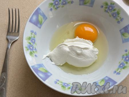 Для приготовления заливки в глубокой тарелке нужно соединить сметану и сырое яйцо, перемешать вилкой.