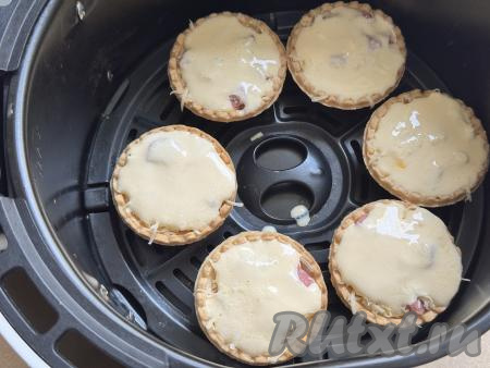 Аккуратно влить заливку в тарталетки, находящиеся в аэрогриле. Оставшуюся заливку непосредственно перед запеканием нужно будет распределить по 4 тарталеткам, которые не поместились в чашу аэрогриля.