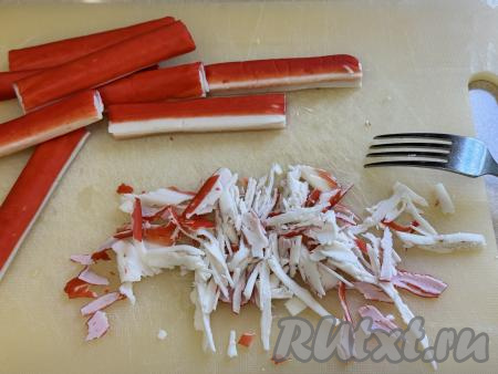 Крабовые палочки очистить от упаковки и с помощью вилки разорвать на волокна (или просто мелко нарезать).&nbsp;