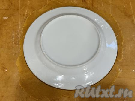 Каждую часть теста на тефлоновом коврике или на пергаменте, присыпая по мере надобности скалку мукой, раскатать в круг диаметром 19 сантиметров. Для того чтобы подравнять края круга, нужно поверх раскатанного теста выложить перевёрнутую тарелку диаметром 19 сантиметров. Тесто, выходящее за края тарелки, обрезать.