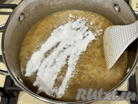 Как только карамель закипит, всыпать соду в кастрюлю.