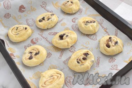 Застилаем противень пергаментом (или ковриком для выпечки), выкладываем получившиеся улитки  с изюмом из слоёного теста. В небольшой ёмкости взбиваем вилкой яйцо до однородности. С помощью силиконовой&nbsp;кисточки смазываем улитки яичной смесью.